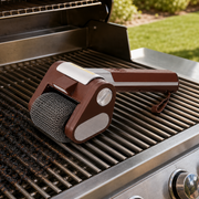 Cordless electric grill brush cleaning stubborn residue from an outdoor barbecue grate